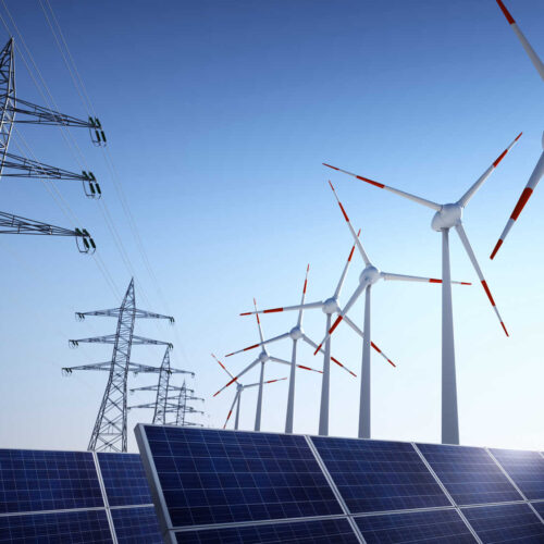 Electrical poles of high voltage and wind turbines in blue sky