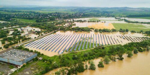 aerial view of flooded solar power station with dirty river water in rain season