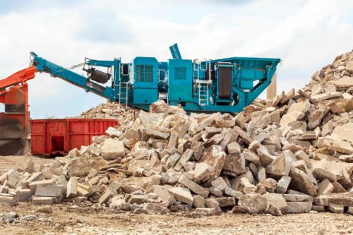 Recycling concrete at a building demolition site.