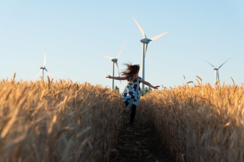 wheat field with girl and wind turbines