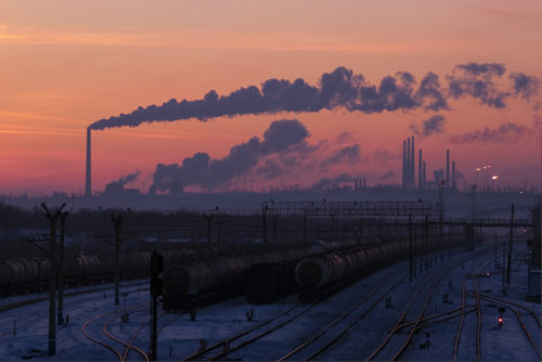 Railway station and gas-processing factory on horizon.