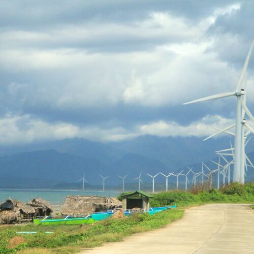 row of wind turbines near beach